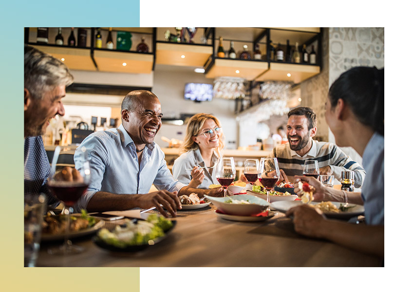 Group of six friends having coffee and laughing